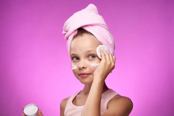 Menina com uma toalha em sua cabeça cosméticos decoração close-up roxo fundo — Fotografia de Stock