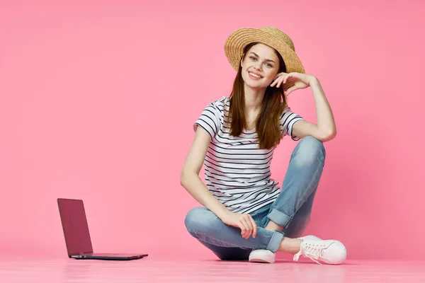 Žena sedí na podlaze s notebookem nákupy zábava růžové pozadí — Stock fotografie