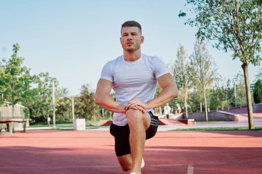 Adam dışarıda oyun sahasında egzersiz yapıyor.