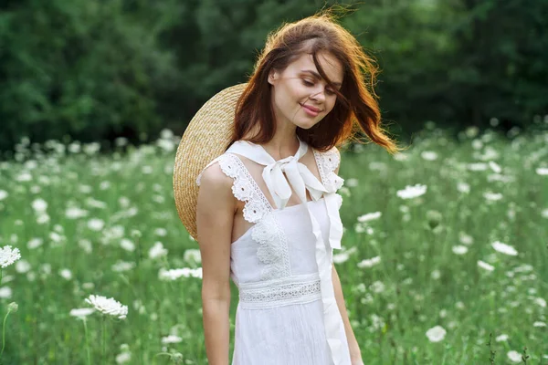 Donna in abito bianco in un campo a piedi fiori natura vintage — Foto Stock