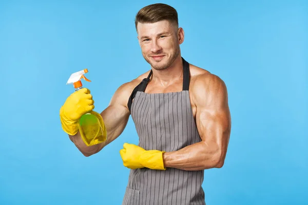 Egy férfi felpumpált testtel kötényben mosószer tisztítás — Stock Fotó