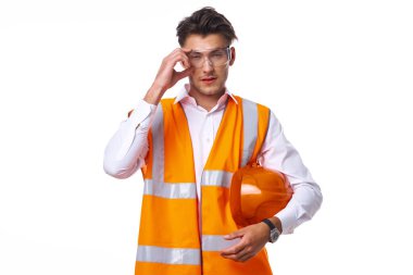 Turuncu üniformalı bir adam inşaat işinde.