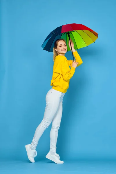Vrouw met veelkleurige paraplu in gele trui poseren regenboog kleuren — Stockfoto