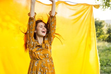 Elleri havada neşeli bir kadın poz veriyor.