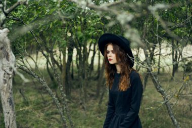 Cadılar Bayramı 'nda cadılar bayramı için ormanda poz veren cadı.