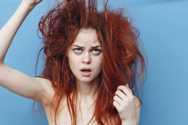 Женщина с рыжими волосами расческа уход синий фон — стоковое фото