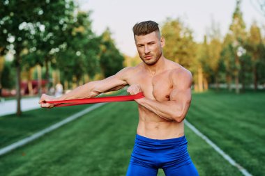 Parkın spor salonunda şişkin vücutlu atletik bir adam.