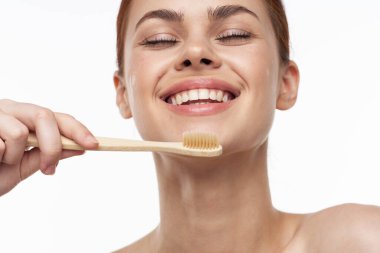 Çıplak omuzlu, neşeli bir kadın diş fırçası, diş fırçası, ağız bakımı.