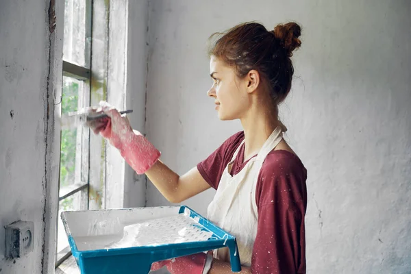 Woman painter makes home repairs near window interior — Stock Photo, Image