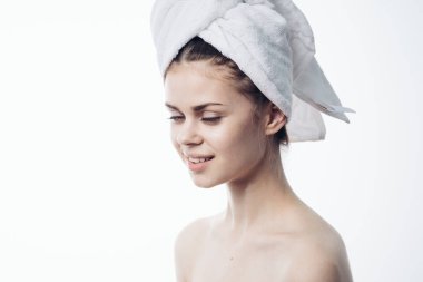 Duştan sonra kadın başındaki havluyla cilt bakımı yapıyor.