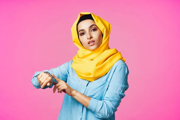 Kobieta w żółtym hijab elektroniczny zegarek technologia różowy tło — Zdjęcie stockowe
