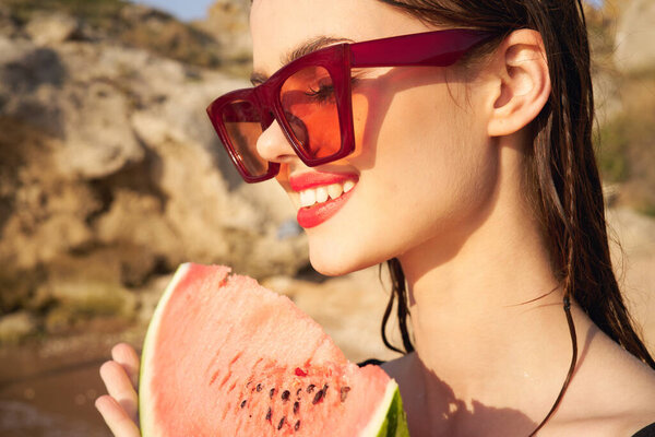 cheerful woman in sunglasses and watermelon nature rocks