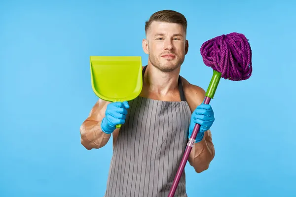 Muž v zástěře s mop představovat svalnaté tělo domácí práce — Stock fotografie