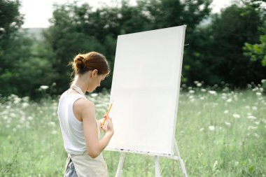 Kadın açık havada yaratıcı bir resim çiziyor.