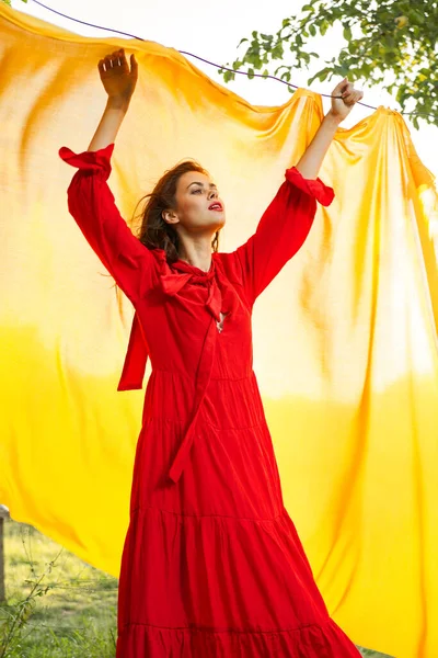 Festligt utomhus gul duk på bakgrunden av poserar röd klänning — Stockfoto