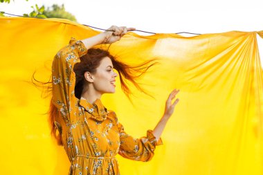 Elleri havada neşeli bir kadın poz veriyor.