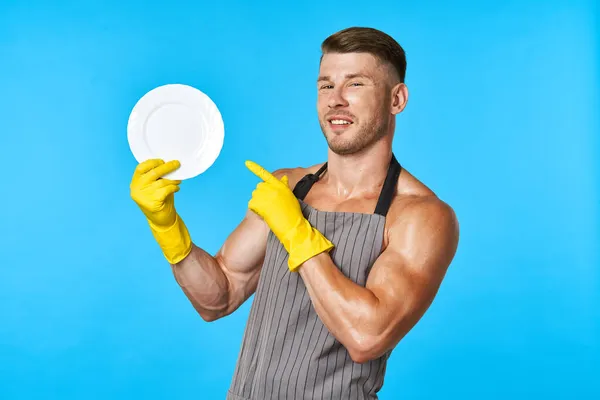 Посудомоечная машина резиновые перчатки пластины в руках синий фон — стоковое фото
