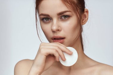 Pamuklu ped ve temiz cilt bakımı cazibesi olan güzel bir kadın.