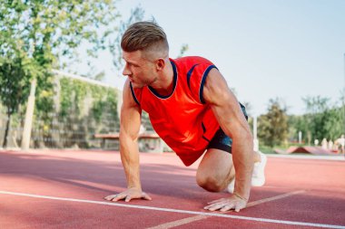 Spor sahası egzersizlerinde kaslı sporcular.