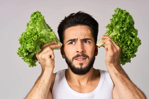 L'homme joyeux feuilles de laitue aliments sains posant — Photo