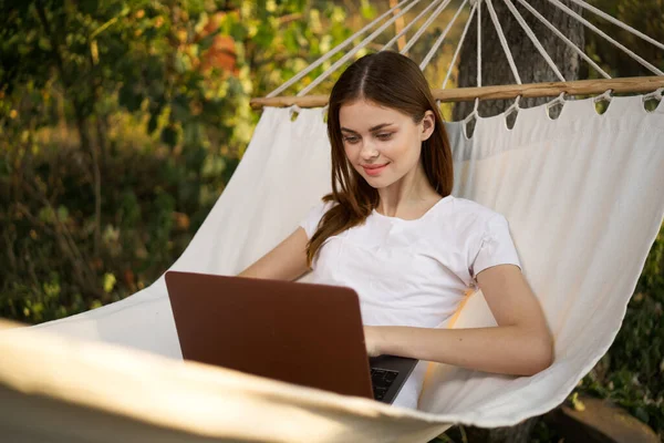 Kobieta leży w hamaku z laptopem na wakacje natury podróży — Zdjęcie stockowe