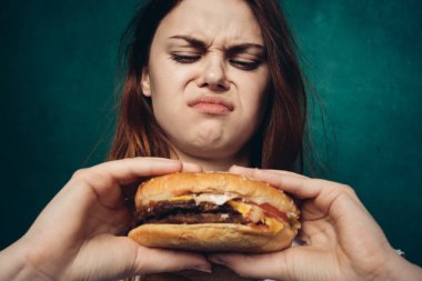 Hamburger yiyen bir kadın.