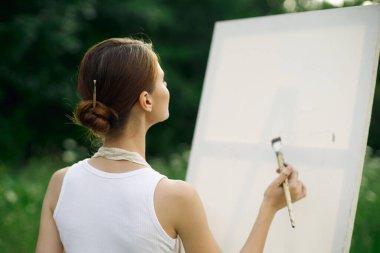 Kadın ressam açık havada yaratıcı manzara çiziyor.