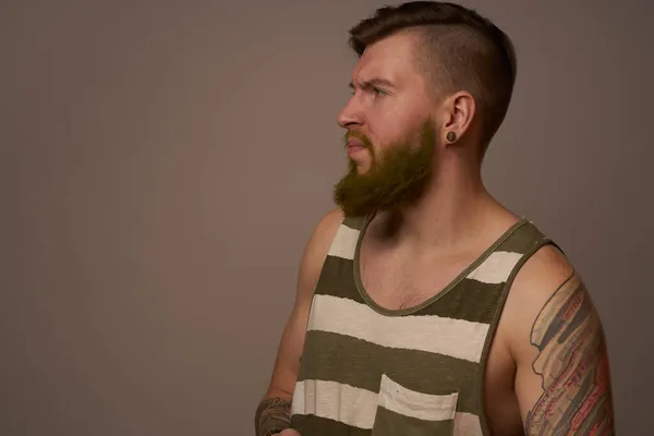 Fashionable man with tattoos on his arms stylish hairstyle self-confidence studio — Stock Photo, Image