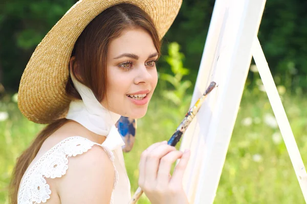 Mulher em branco vestido artista pinta na natureza paleta criativa — Fotografia de Stock