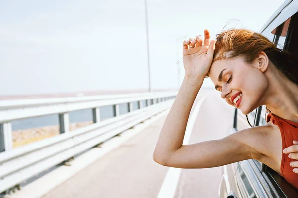 Fröhliche Frau blickt aus dem Autofenster — Stockfoto