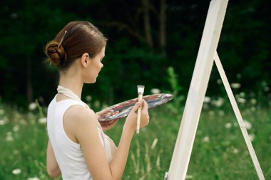 Kadın açık havada resim çiziyor yaratıcılık üzerine bir hobi.