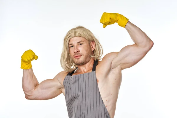 Мужчина в жёлтых резиновых перчатках в женских париках — стоковое фото
