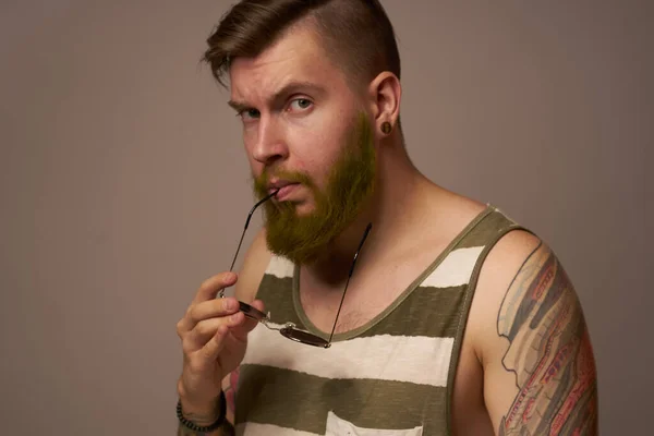 Uomo barbuto a strisce t-shirt occhiali tatuaggio sulle braccia moda — Foto Stock