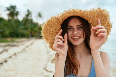 Yazın okyanus adasının yanındaki plaj şapkalı neşeli kadın