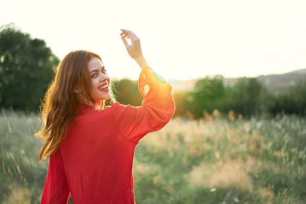 Mulher em vestido vermelho no campo andar paisagem liberdade — Fotografia de Stock