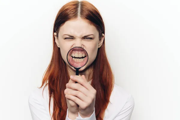 Mooie vrouw grimacing met vergrootglas in de buurt gezicht — Stockfoto