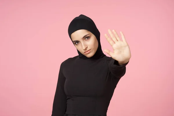 Весела мусульманка чорний хіджаб позує рукою жест рожевий фон — стокове фото