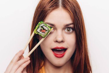 Suşi çubukları yiyen güzel bir kadın.