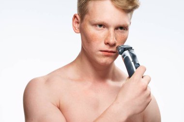 Adam çıplak vücut pozu vererek cilt bakımı yapıyor.