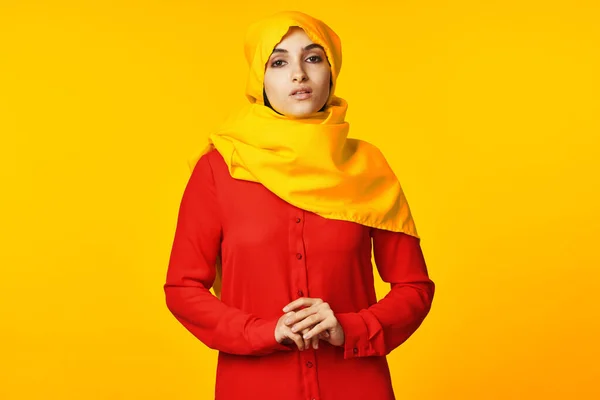 身穿黄色头巾的穆斯林妇女摆出族裔黄色背景 — 图库照片