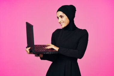 Dizüstü bilgisayar eğitimi alan neşeli Müslüman kadın internet teknolojisi öğrencisi.