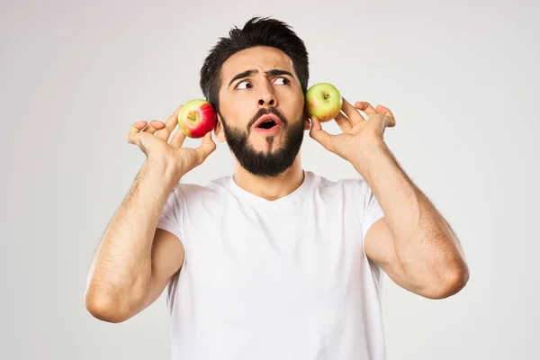 Hombre alegre con manzanas en las manos en una camiseta blanca frutas — Foto de Stock