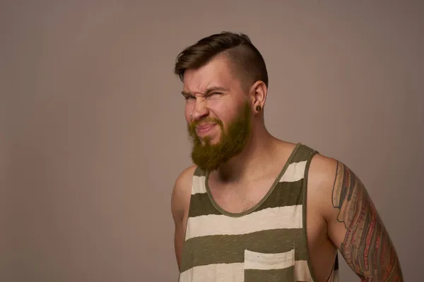 Nationale bebaarde man in een gestreepte trui hipster tatoeages op zijn armen — Stockfoto