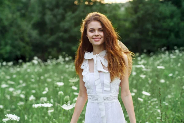 Kvinna i vit klänning i ett fält promenad blommor vintage natur — Stockfoto