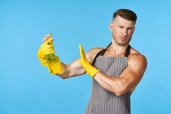 Man met een schort schoonmaakmiddel huishoudelijk werk — Stockfoto