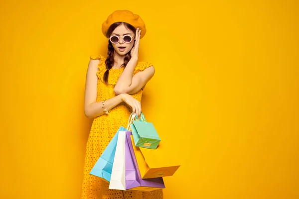 Okouzlující žena ve žlutém klobouku Shopaholic módní styl žluté pozadí — Stock fotografie