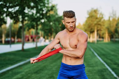 Parkın spor salonunda şişkin vücutlu atletik bir adam.