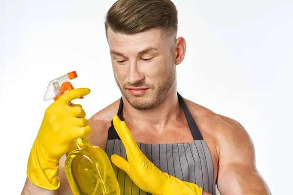 Hombre alegre en delantal detergente posando músculos — Foto de Stock