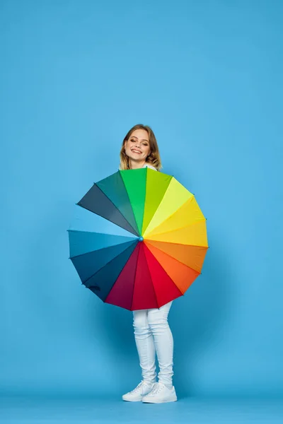 Mujer de moda con paraguas colores arco iris posando fondo azul — Foto de Stock