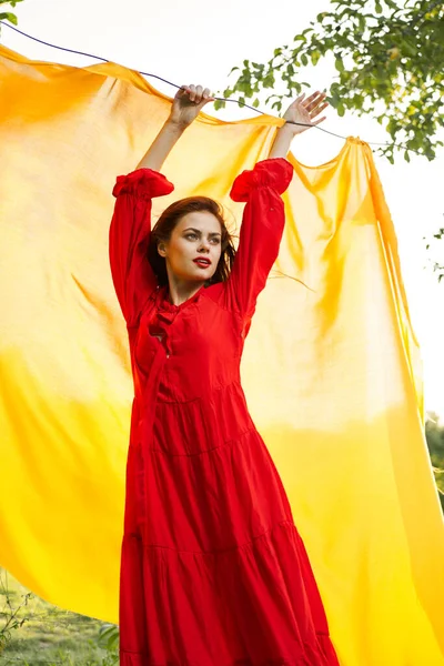 Festligt utomhus gul duk på bakgrunden av poserar röd klänning — Stockfoto